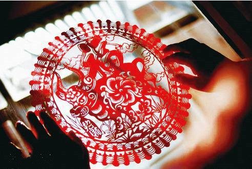 A traditional circular paper-cut medallion held up to the light