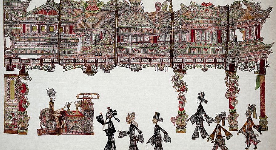 A complete shadow puppet theater set: palace backdrop pieces and many carved figures laid out