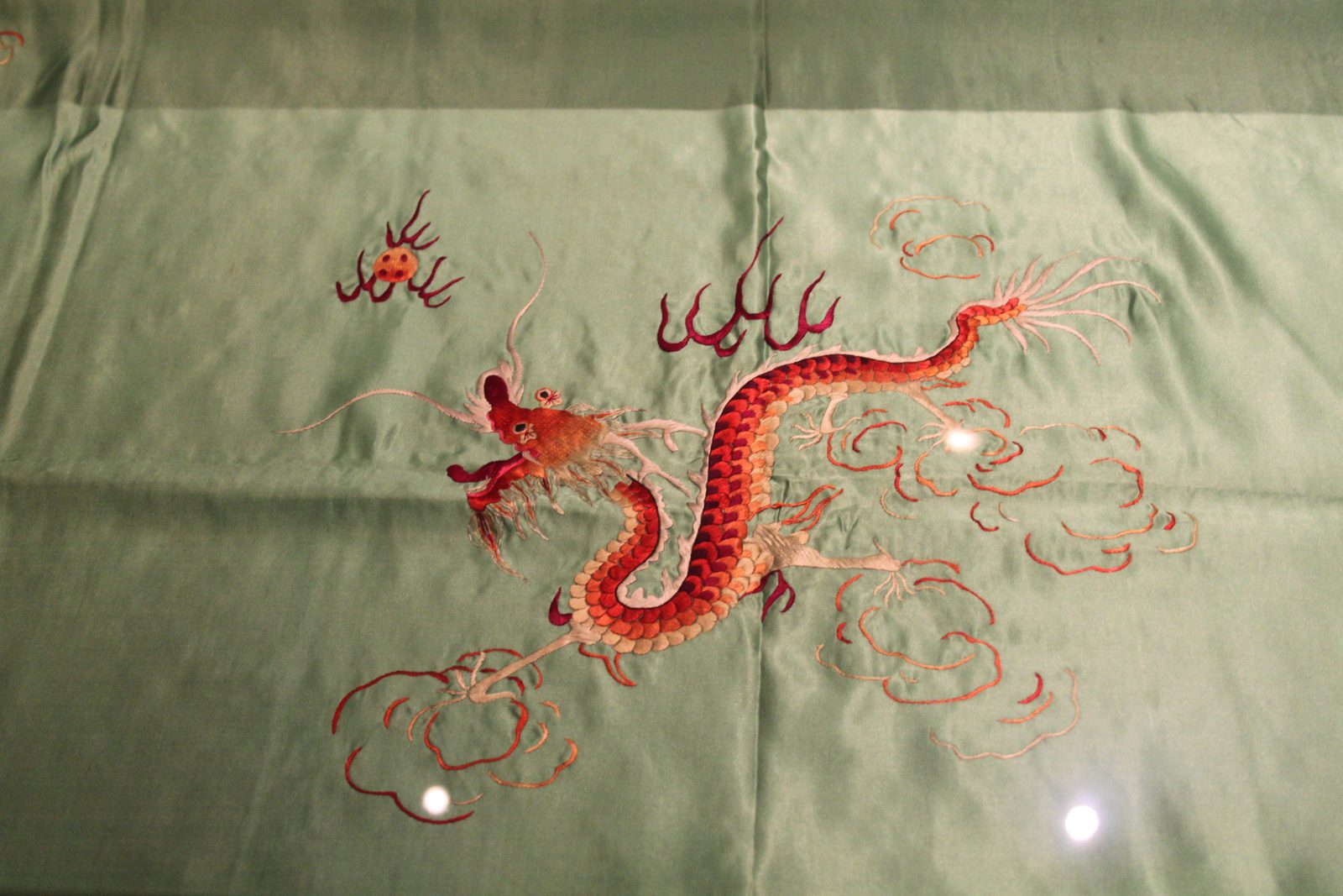 A Sichuan embroidery piece showing a dragon amid clouds, illustrating the school’s bold color and smooth stitching
