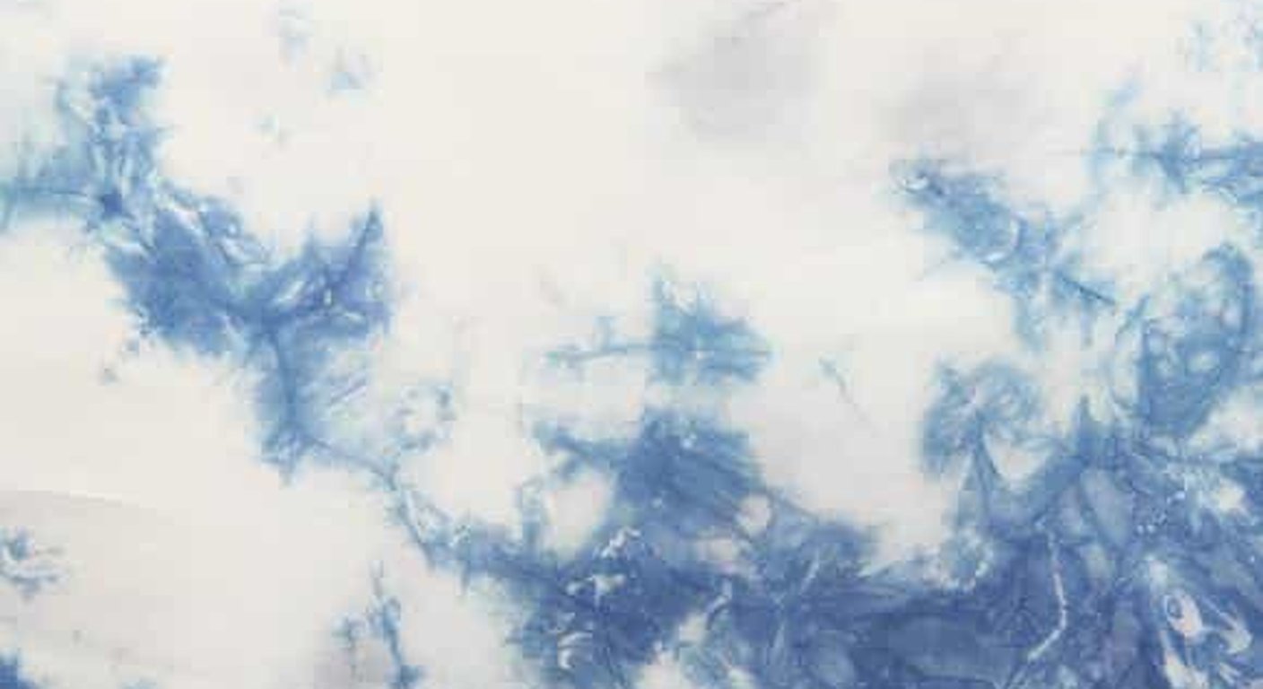 Close-up of Chinese tie-dye cloth showing cloud-like indigo patterns blooming across white cotton
