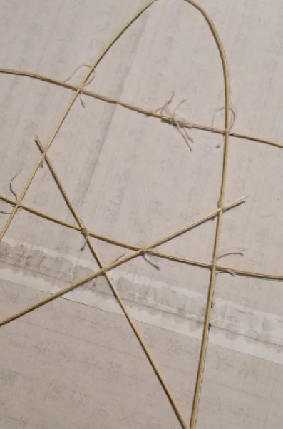 The bamboo skeleton of a Chinese kite: bent bamboo strips lashed into a fan-shaped frame